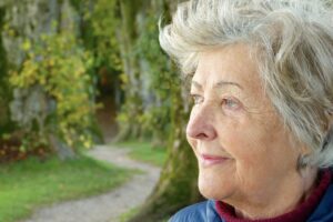 Elderly lady on a woodland path